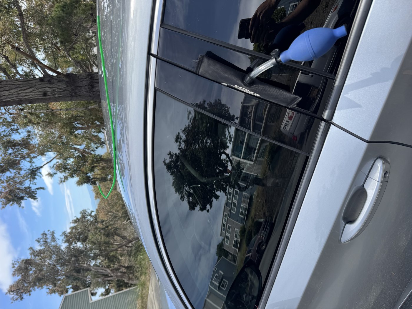 Car lockout service using air wedge tool on silver sedan - San Francisco Bay Area